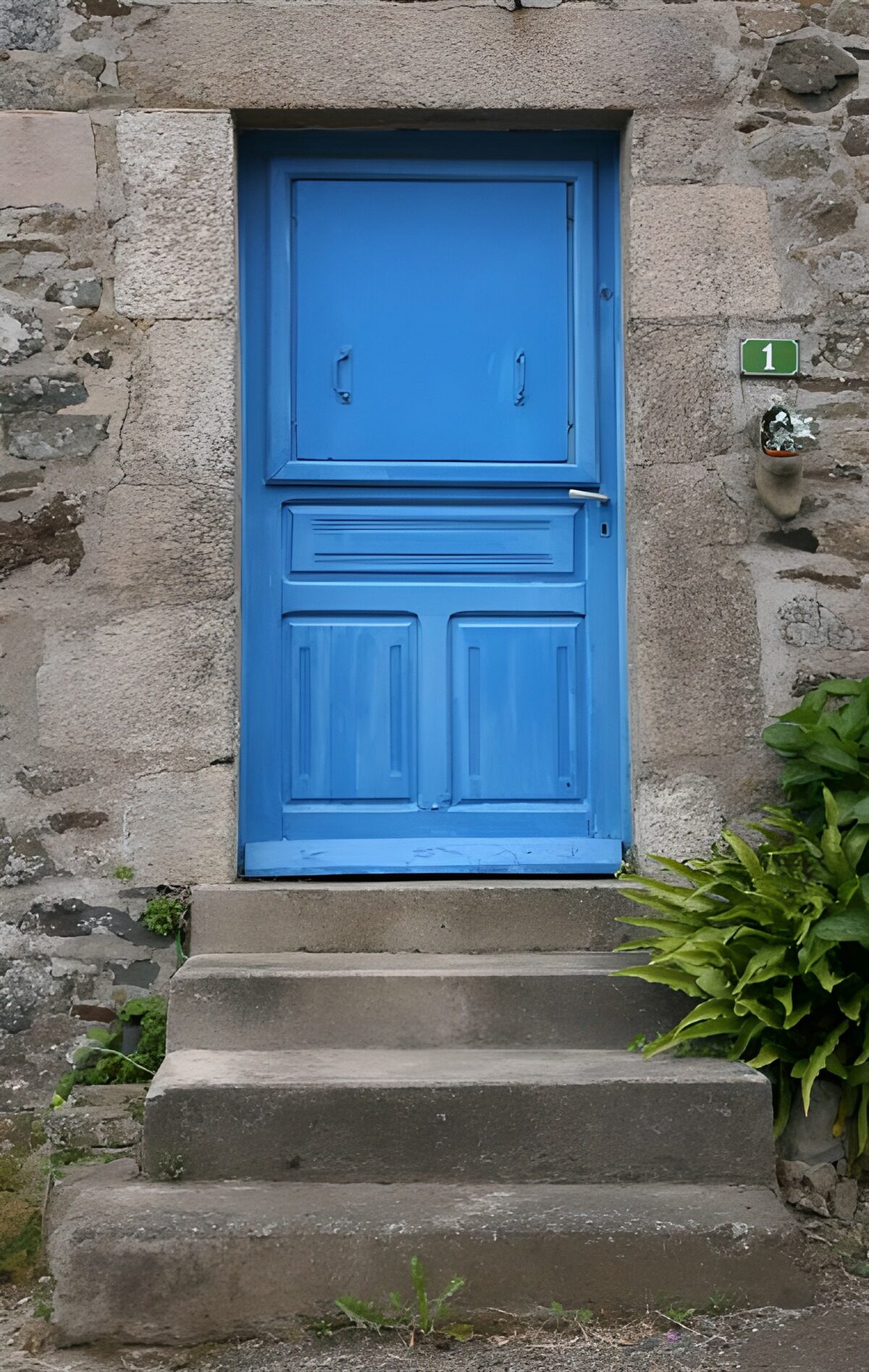 Porte de maison bleue en haut d'un escalier