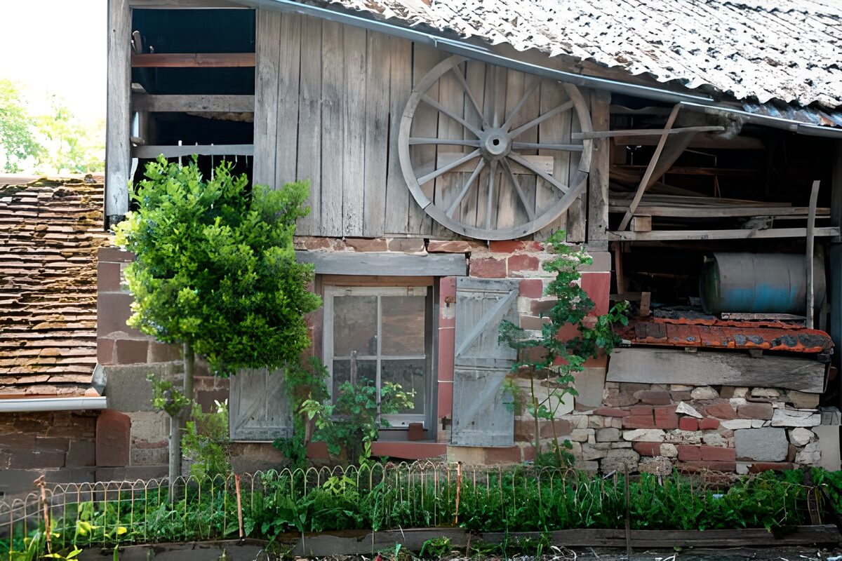 Vieille ferme française avec volets et roue accrochée en façade version 2