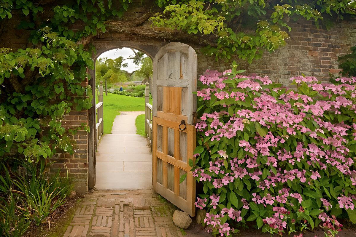 Porte bordée de fleurs donnant sur le jardin