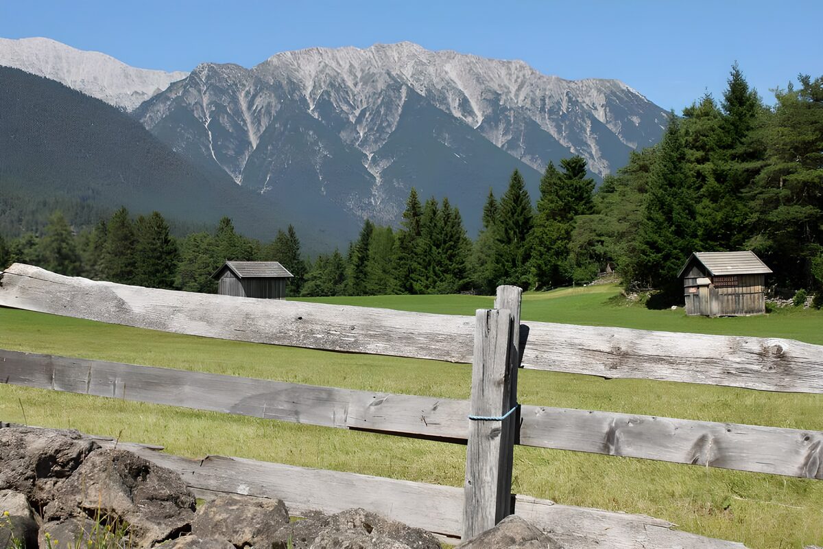 Étables dans une prairie avec une barrière en avant-plan