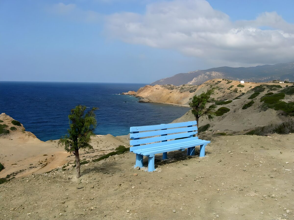 Banc bleu sur fond de mer et de collines